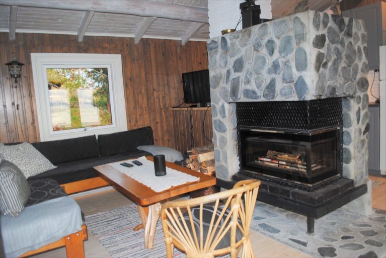 Sofa corner and fireplace at Grindaplassen at Hjellup Fjordbo.