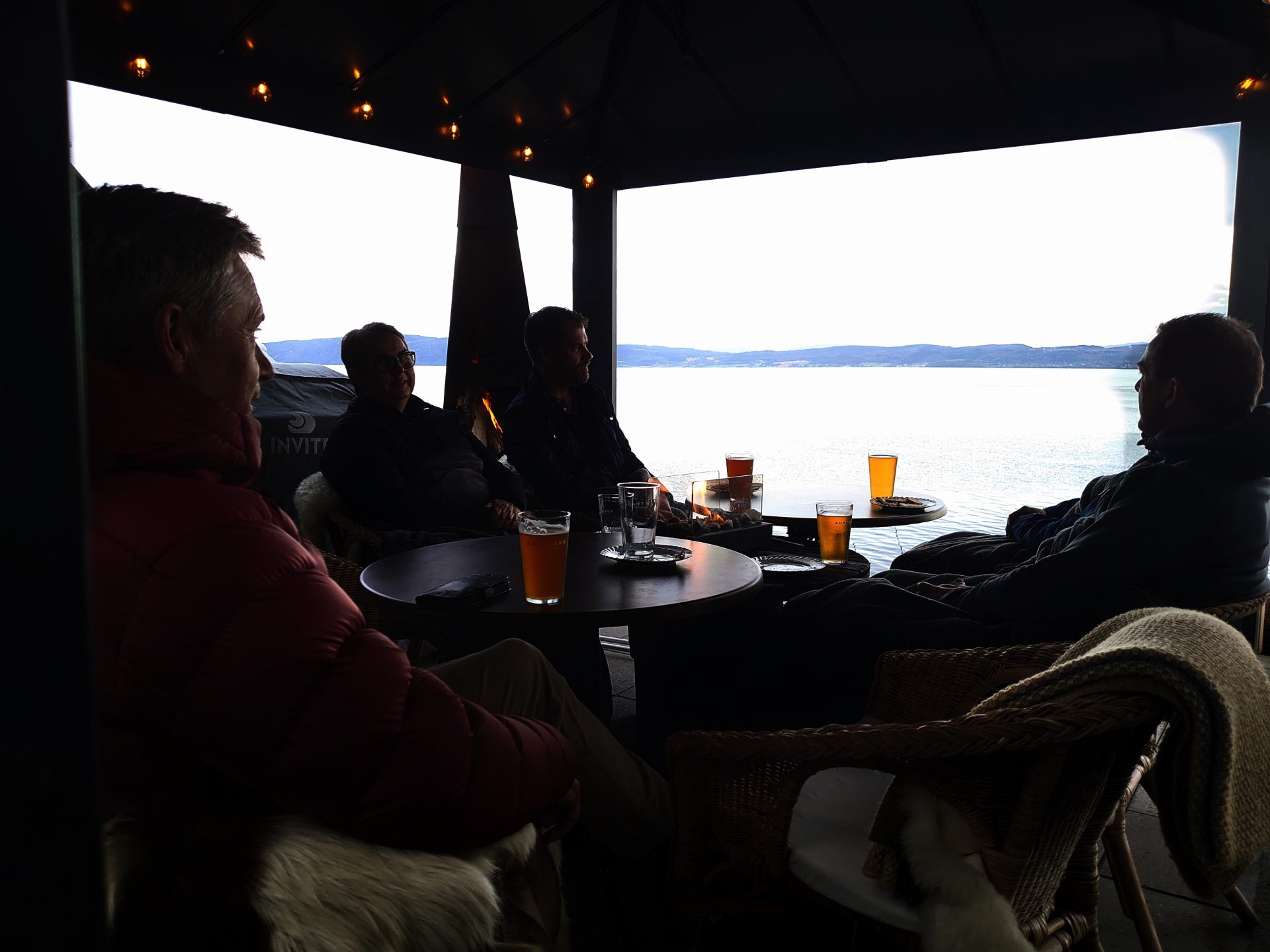 Nach einem langen und anstrengenden Arbeitstag ist es keine schlechte Art, ein gutes Getränk im Freien zu genießen, mit einem Feuer im Kamin und einem Blick auf den Fjord.